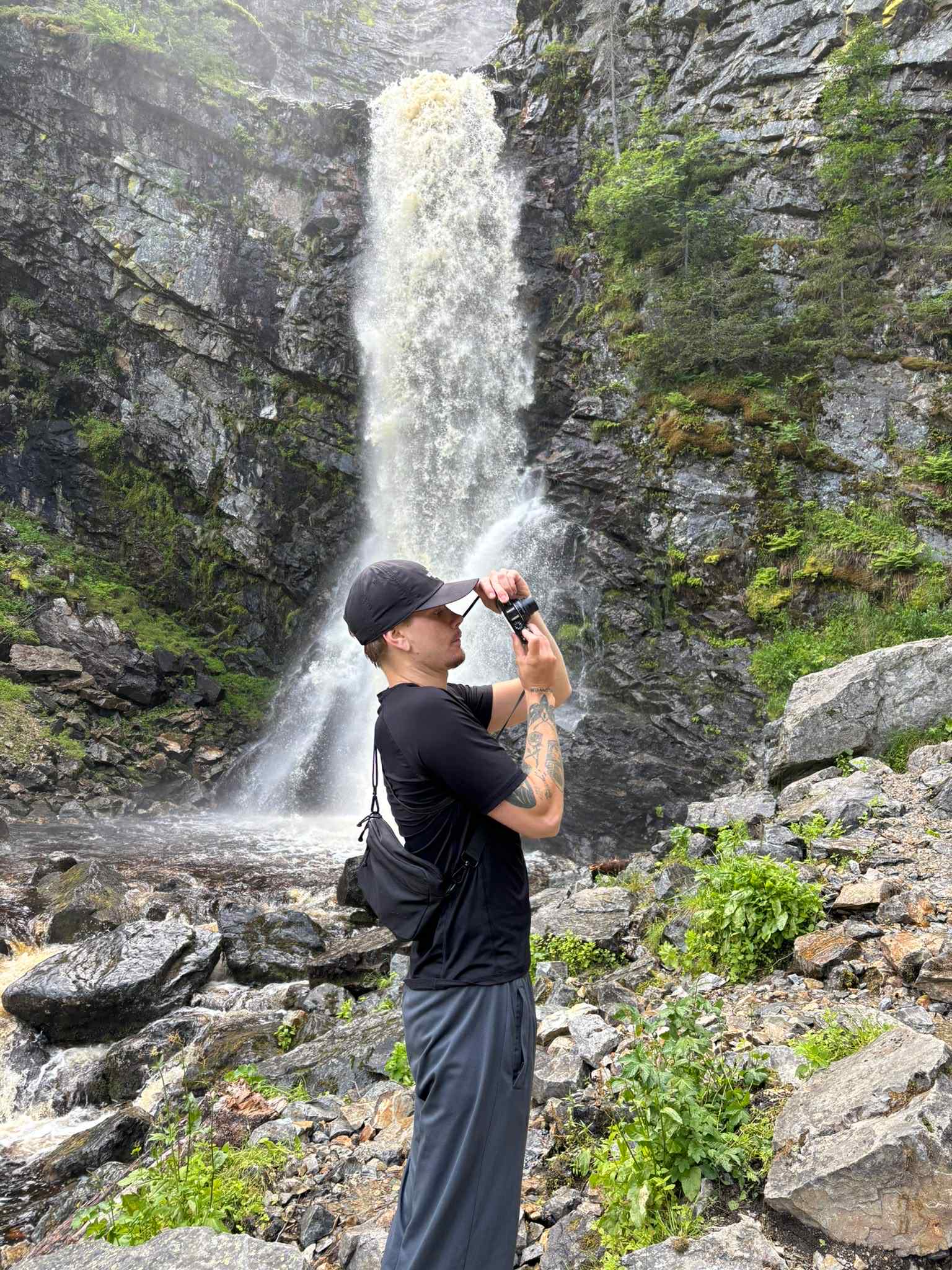 Lucas fotograferar vid ett vattenfall.